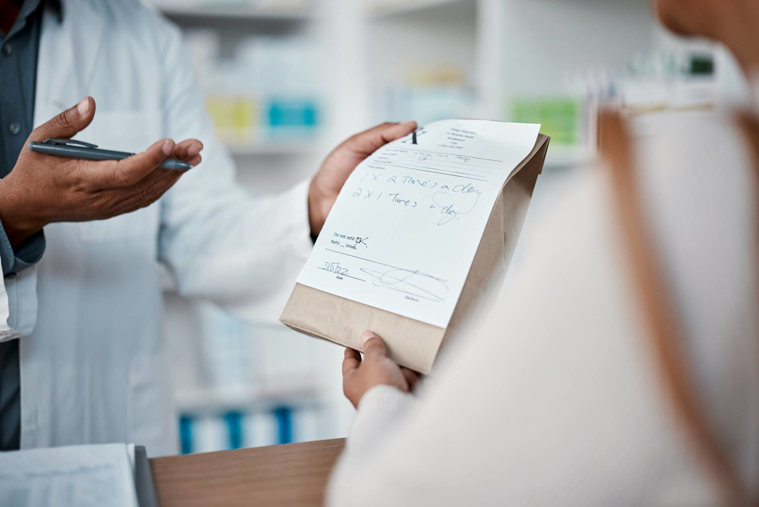 Pharmacist consulting a patient about prescription medication refills at a pharmacy counter