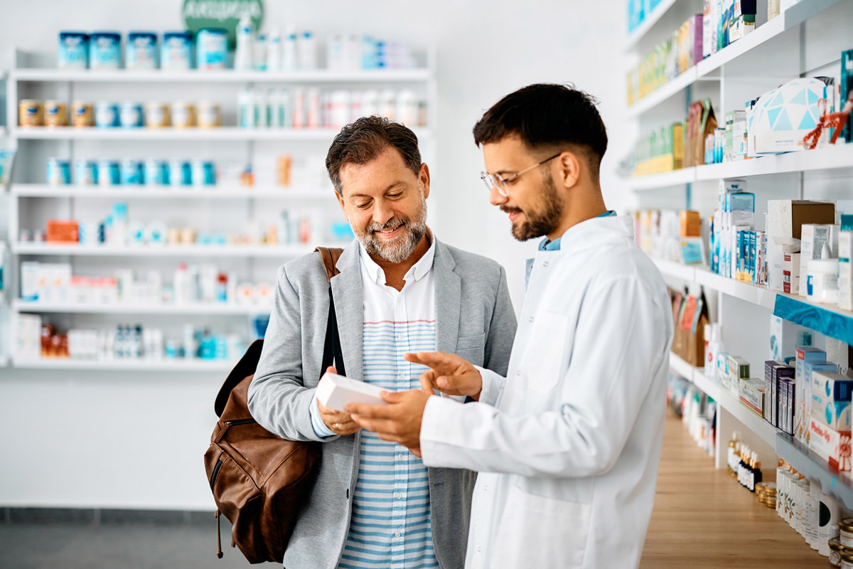 Pharmacy staff providing personalized assistance to a customer inside a well-stocked pharmacy
