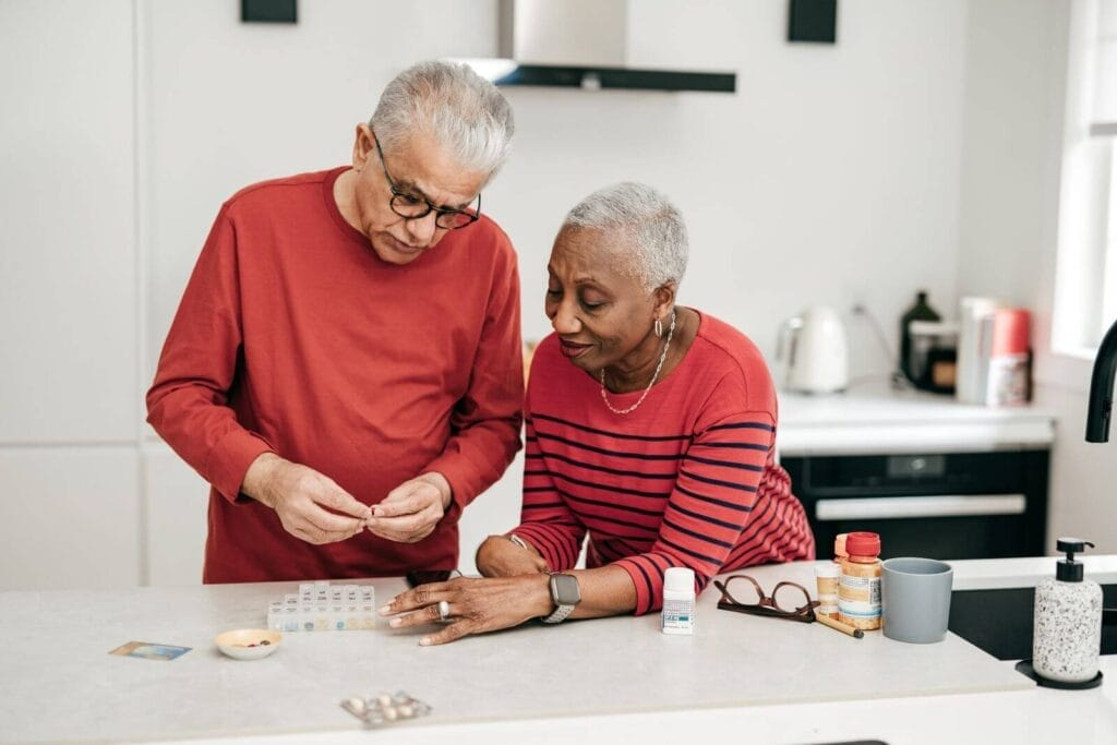 Elderly couple organizing their medications at home, illustrating the importance of convenient prescription management and delivery services