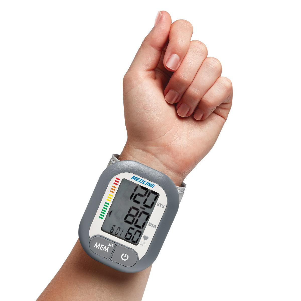 Digital wrist blood pressure monitor displaying blood pressure and pulse readings on a person's wrist