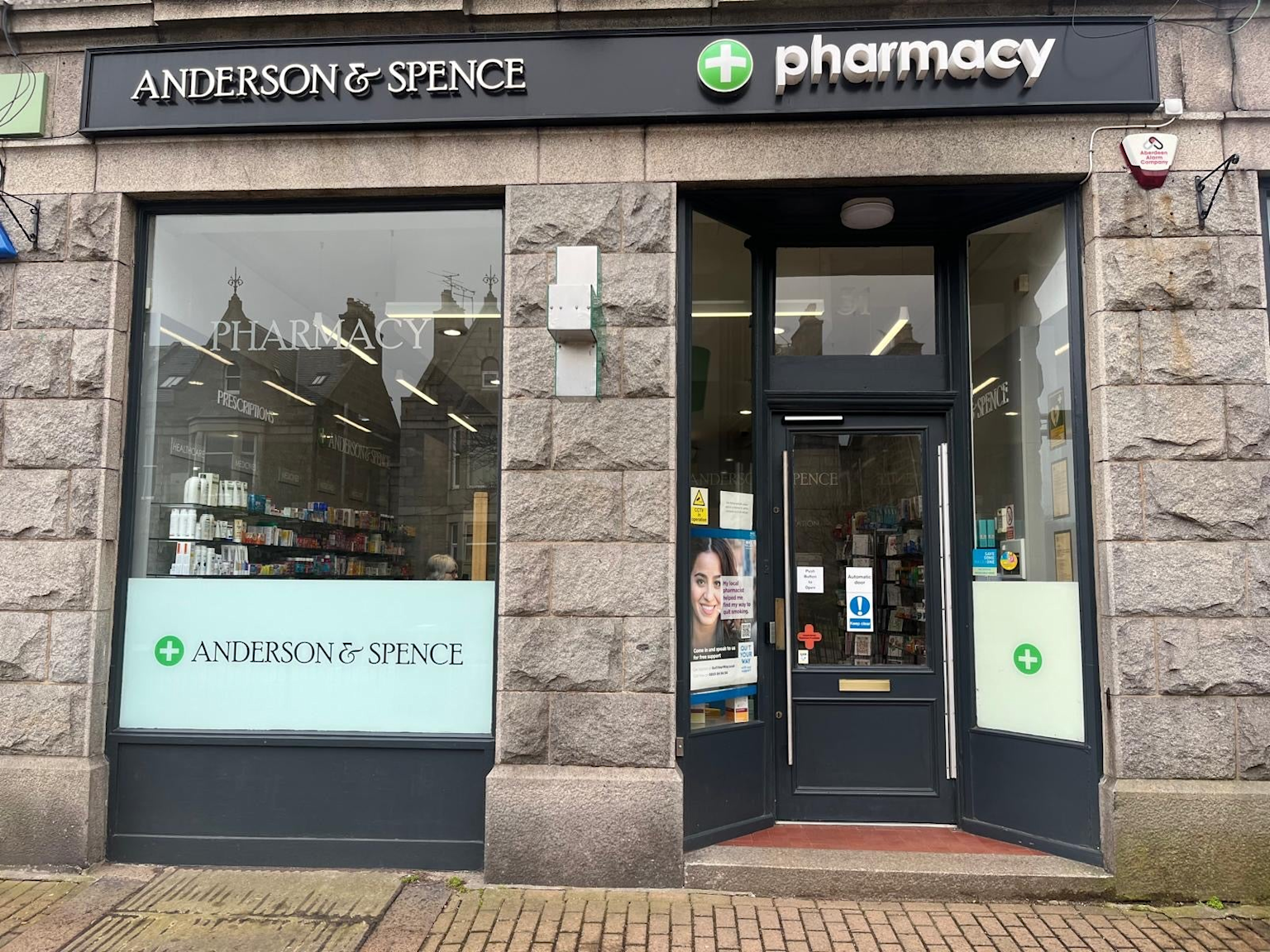 Anderson & Spence independent community pharmacy storefront with traditional stone facade and clear pharmacy signage