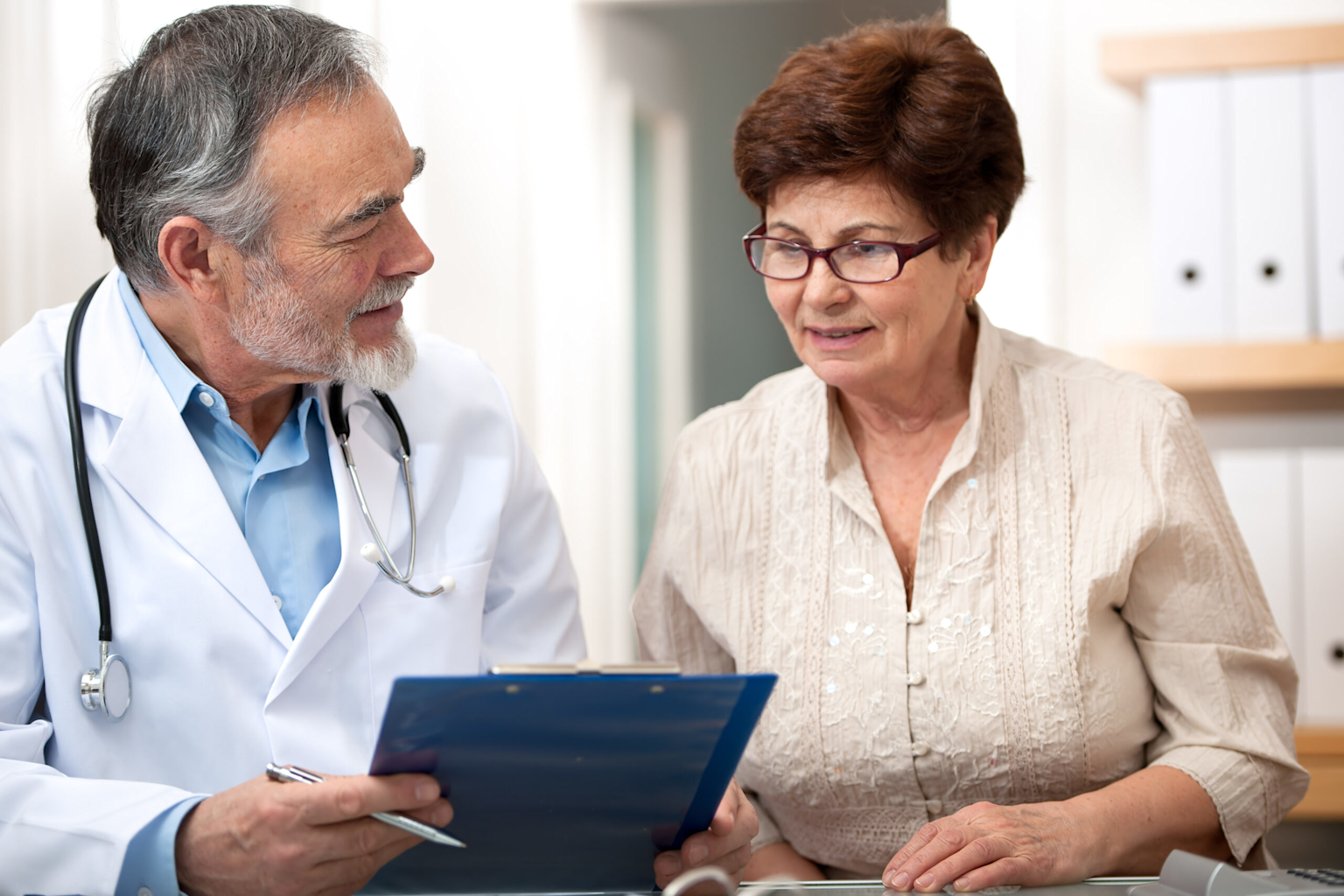 Elderly patient consulting a doctor during a medical appointment about prescription management